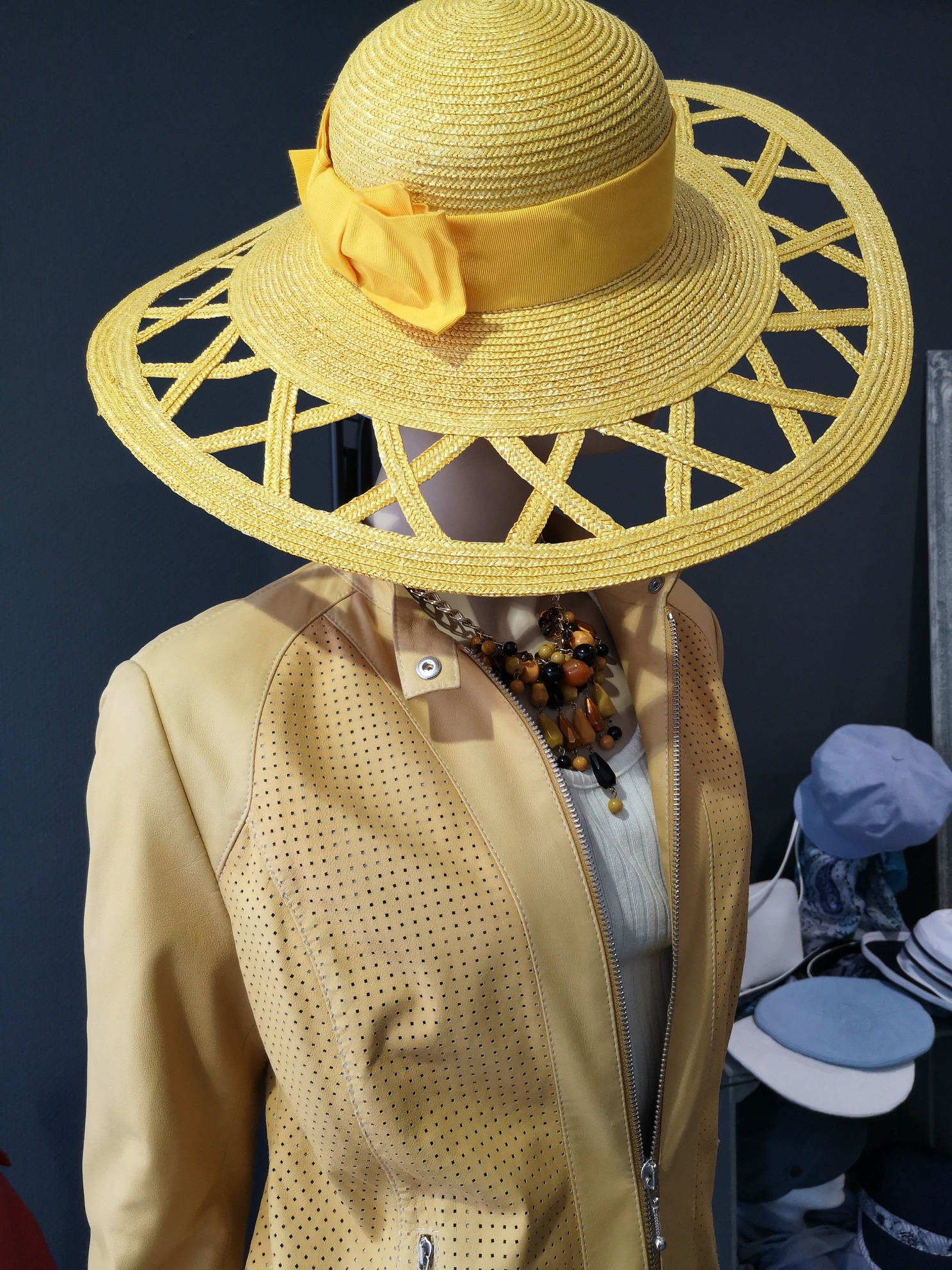 Ein exklusiver Sonnenhut in gelb mit ausladendem Rand dazu die passende gelbe Lederjacke