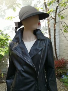 Ein schwarzer Damenhut mit einer schwarzen Bikerlederjacke