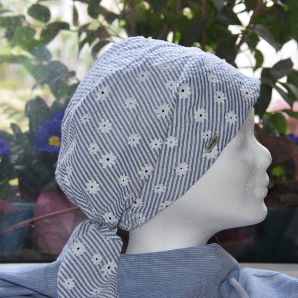 Ein schlichtes Kopftuch mit weißen Blumen und blau-/weißen Streifen